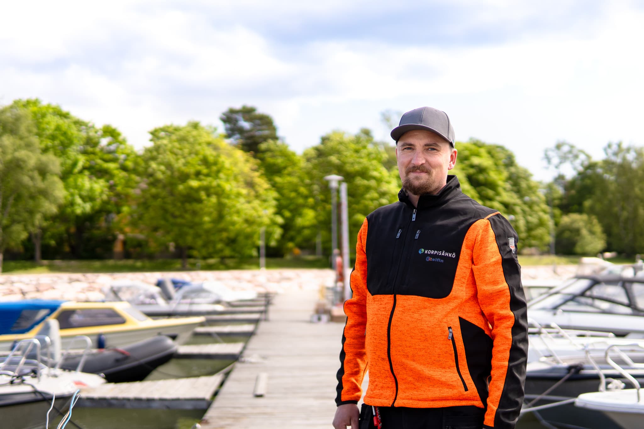 Korpisähkön asentaja huoltoauton luona talvisessa pihassa